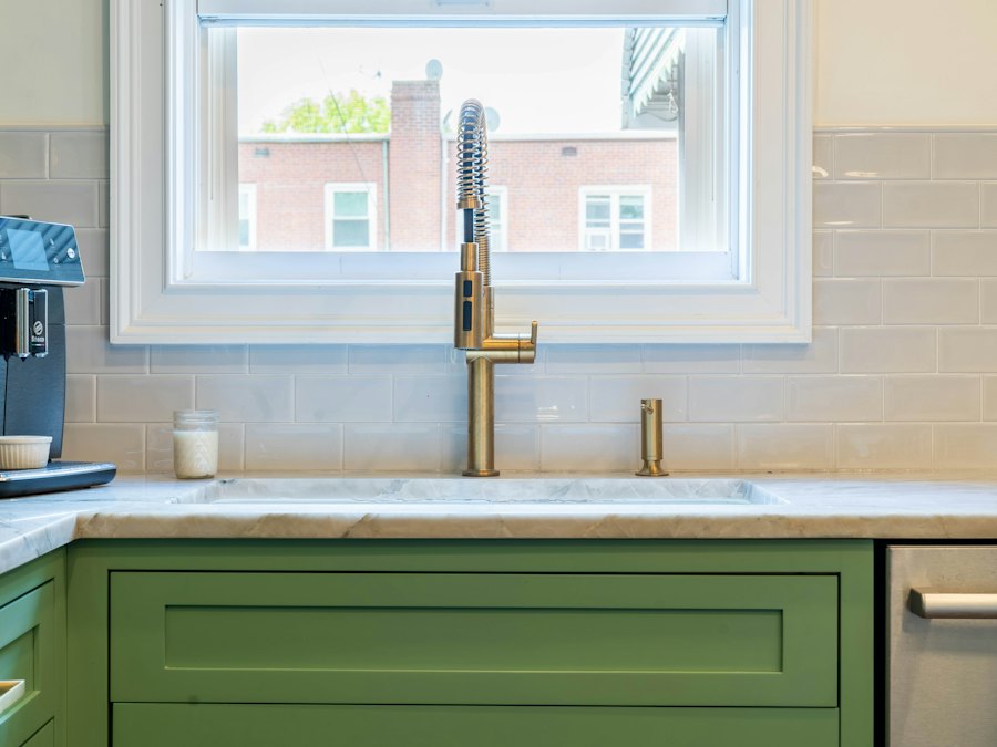 Green shaker cabinets with brass faucet and hardware